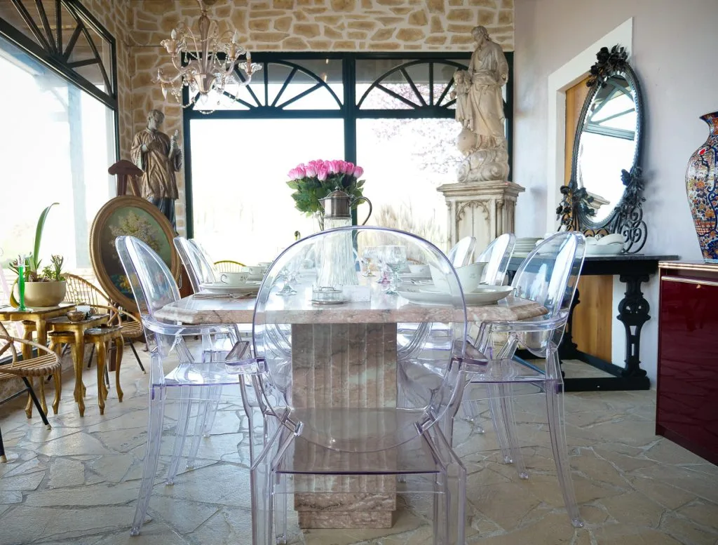 Table en marbre entourée de statues et vaisselle ancienne au dépôt