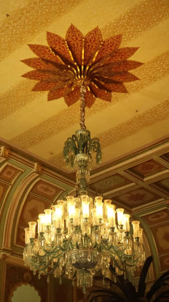 Lustre en cristal suspendu à un plafond richement décoré de style classique